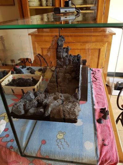 L'aquarium posé sur la vitre arrière et les premières pierres collées